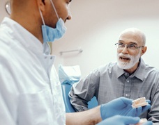 Denture dentist in DeSoto explaining implant denture cost