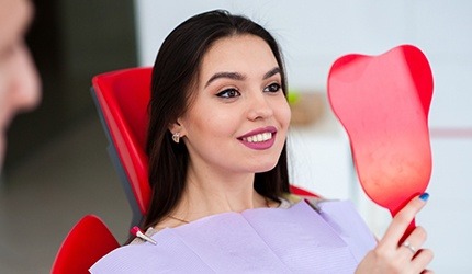 Woman looking at smile in mirror