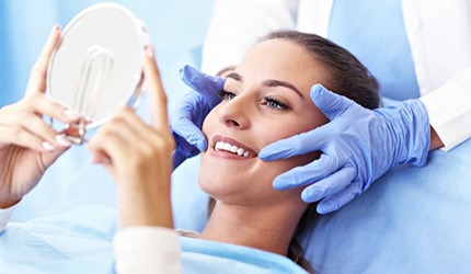 woman admiring her smile after getting dental bonding in DeSoto