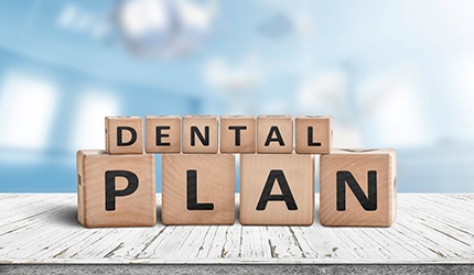 Wooden blocks spelling out “dental plan”