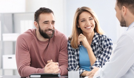 A couple discussing with a dental professional