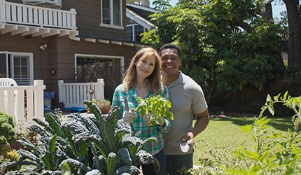 a couple outside in their backyard gardening