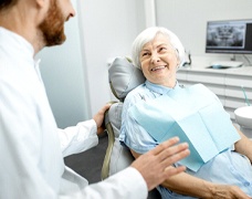 Dentist explaining cost of dentures in DeSoto to patient