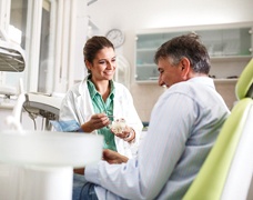 Dentist talking to patient about cost of dentures in DeSoto