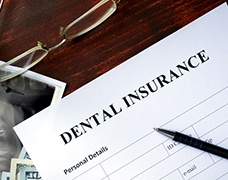 A dental insurance form on a wooden desk