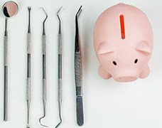 A piggy bank with dentist tools