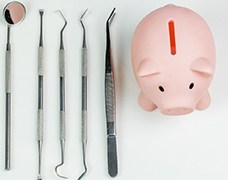 A piggy bank with dentist tools