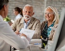 senior man and woman at a dental implant consultation 