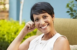 Older woman smiling and sitting outdoors