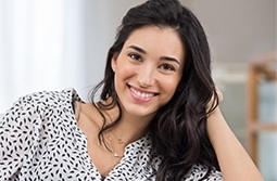 Young woman smiling and resting her head in her hand