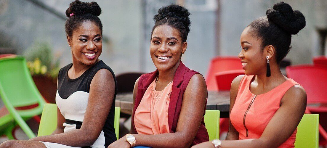 Three women laughing together outdoors