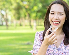 Woman holding aligner for Invisalign in DeSoto, TX