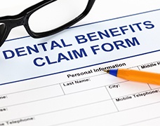 Dental insurance form with glasses and pen