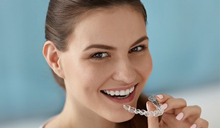 Woman placing Invisalign tray