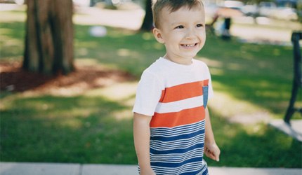 little boy smiling outside  