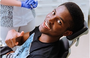 Man in dental chair giving thumbs up