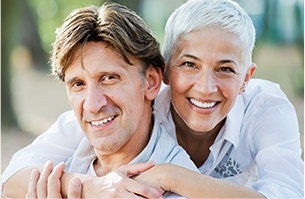 Older man and woman smiling outdoors