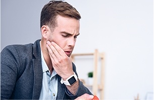 Man holding jaw in pain