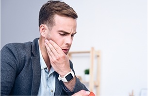 Man holding jaw in pain