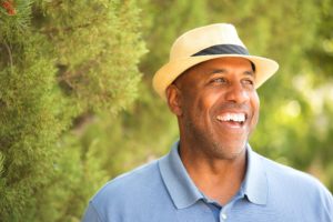 older man in blue polo smiling after seeing cosmetic dentist in DeSoto