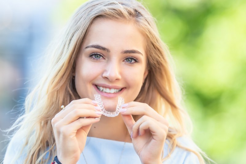 Woman holding Invisalign tray