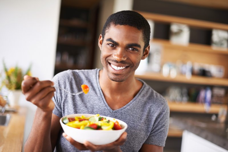 man smiling with food after teeth whitening