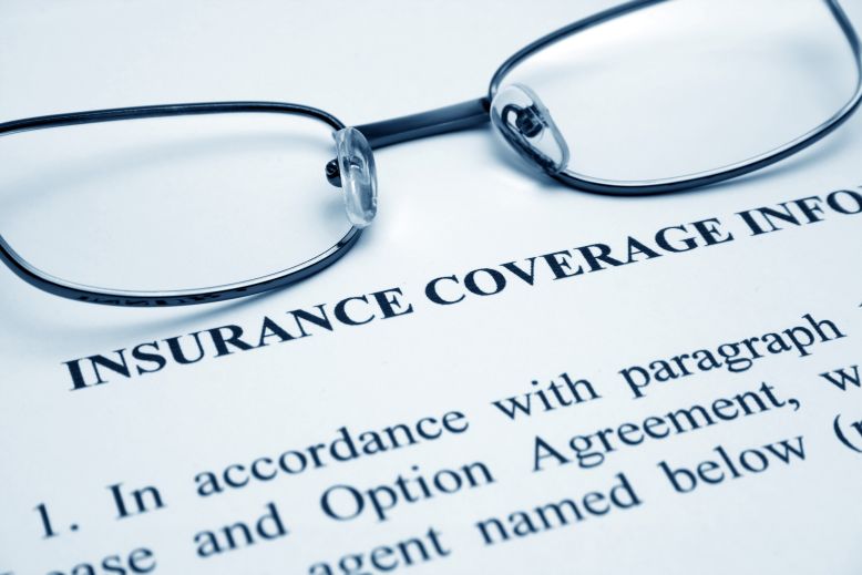 A pair of glasses over a dental insurance form